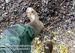 Pissing and jerking off on the street in green overalls and rubber boots