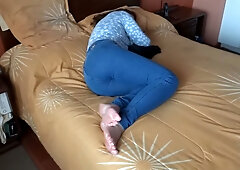 Alone on the yellow bed she pulls down her jeans and touches herself