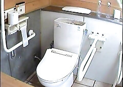 Sitting on a toilet she doesn't know a watchs her