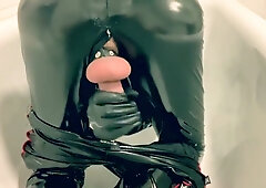Latex-clad figure masturbates in bathtub with vibrator and cumshot
