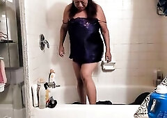 aged woman cleaning bawdy cushion in bathtub with feet. Foot fetish