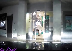 maid clothed under translucent raincoat to cash dipenser