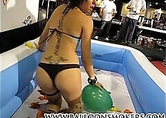 Teen pops balloons inside pool at Exxxotica
