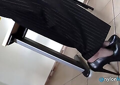 La segretaria toglie le scarpe e mostra i piedi con calze di nylon
