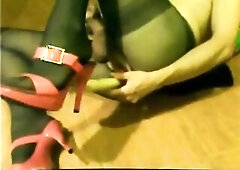 Sissy t-girl doxy in brown hose, green costume, red heals, lengthy sex toy