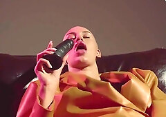 Bald tattooed model pleasures herself with giant black dildo in dim dressing room