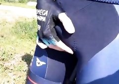 Piss into a cycling bib during street bicycle journey