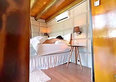 Young couple makes passionate love in a sunlit wooden bedroom
