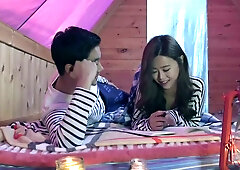 Korean neighbor in a cozy apartment shares an intimate blowjob moment on the couch after late-night studying