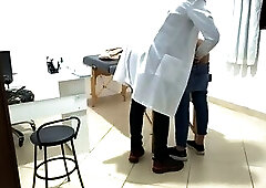 Proctologist performs anal exam on constipated patient.