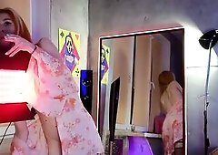 Girl in a nice-looking suit striptease in front of the mirror