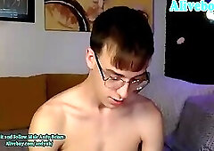cute boy in glasses strokes his big cock