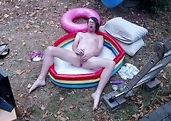 Outdoor WAM sissy gurl in pink pvc micro swimsuit oiled up and drenched in white water plays with herself no jism
