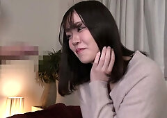 Young Japanese beauty Miho Aikawa gives head on a red couch in a soft-lit room