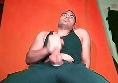 Enjoying a giant knob against a carrot-colored backdrop - GuitarJob's solo guitar jerk-off