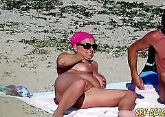 Naked woman are enjoying on the beach, although some guys are around and having fun